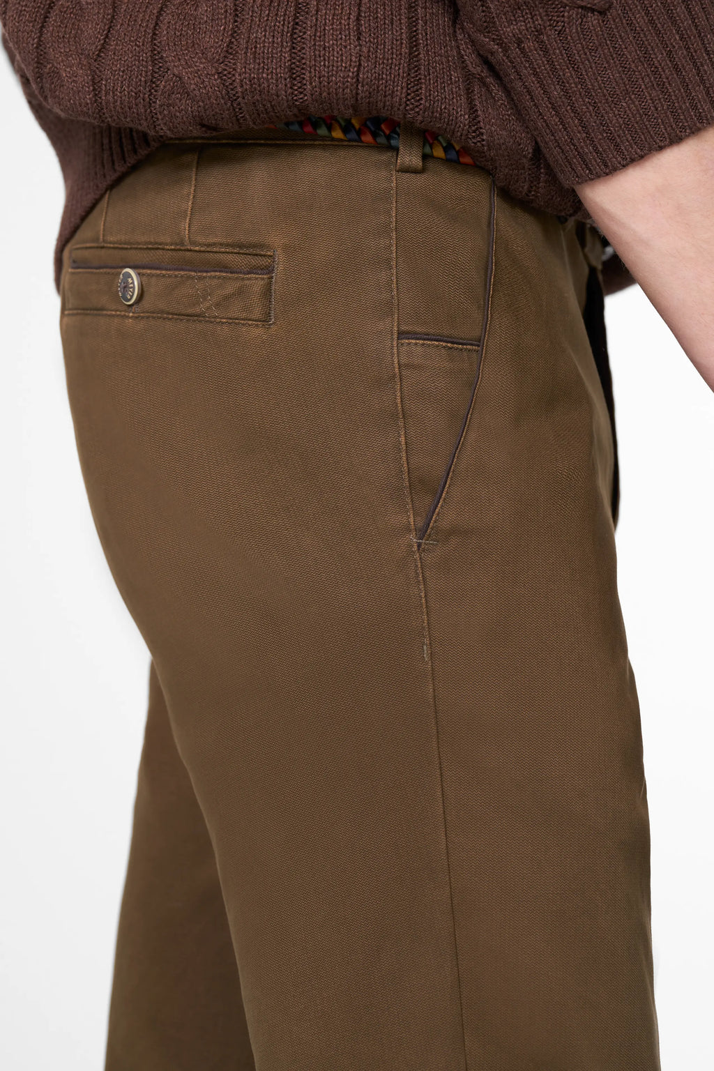 Brown pants worn by a person on a white background